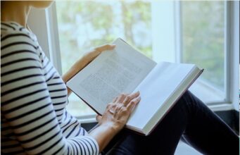 Must-Read Books to Understand the Comfort Women Issue Woman reading a history book by a window, representing research into comfort women history, East Asian wartime historiography, archival sources, survivor testimony, and books about the comfort women debate between Japan and Korea.